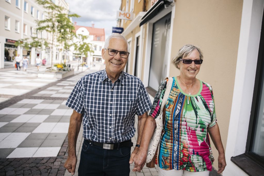 Äldre par håller hand i centrum
